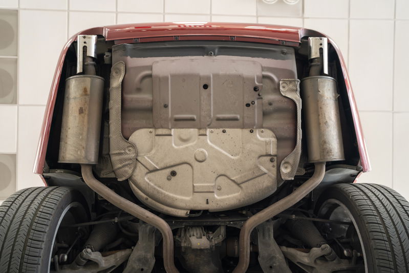 Underside view of a red 2006 Jaguar XJR showing dual exhaust and suspension components.