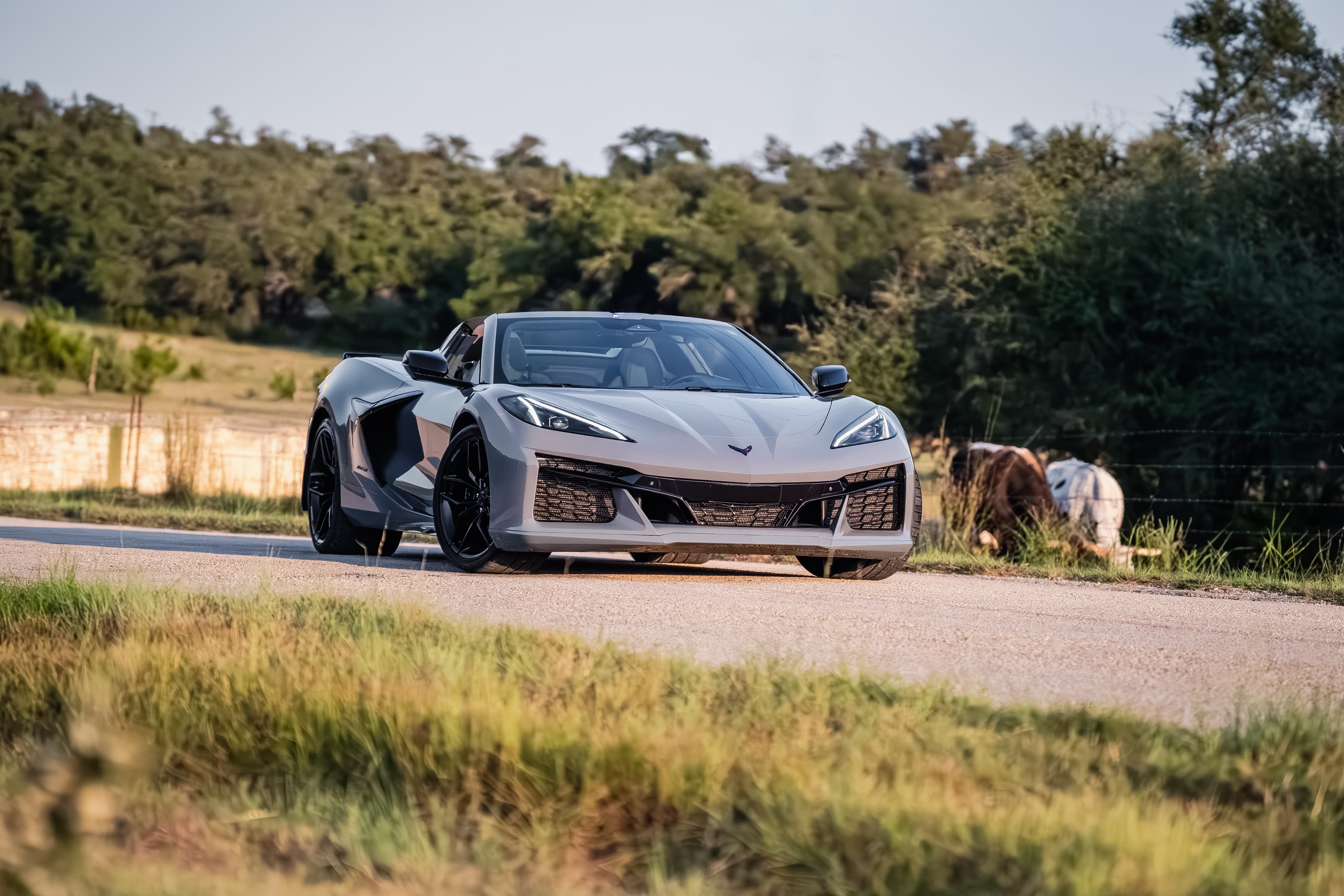 Sea Wolf Gray 2025 Corvette Z06 convertible with black rims parked on a rural road.