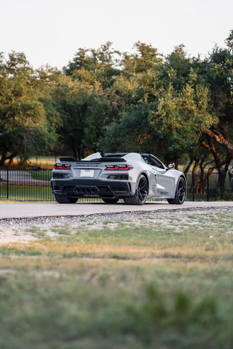 Rear view of a Sea Wolf Gray 2025 Chevrolet Corvette Z06 with black rims and aggressive trim.