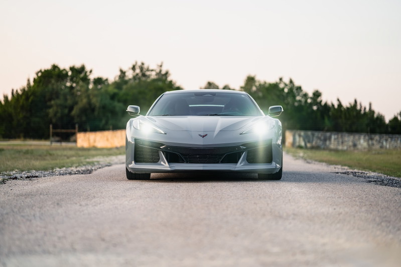 Front view of a Sea Wolf Gray 2025 Chevrolet Corvette Z06, with headlights illuminated.