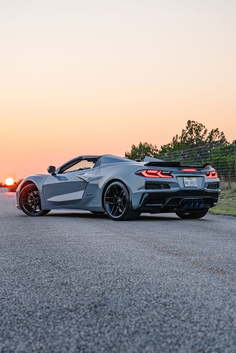 2025 Chevrolet Corvette Z06 in Sea Wolf Gray, rear 3/4 view, black rims, spoiler.
