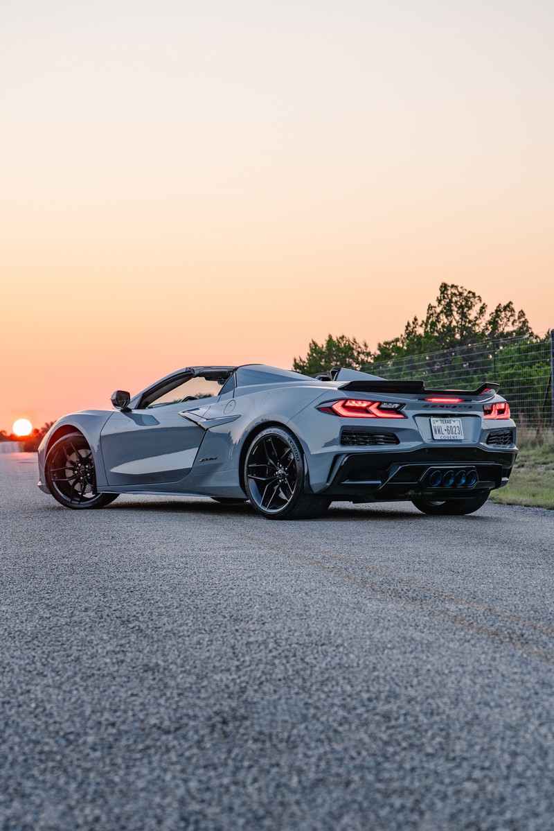 2025 Chevrolet Corvette Z06 in Sea Wolf Gray, rear 3/4 view, black rims, spoiler.