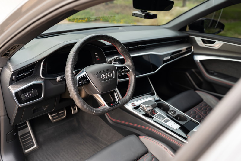 Interior of a Nardo Grey 2022 Audi RS6 with red trim stitching and a sporty steering wheel.
