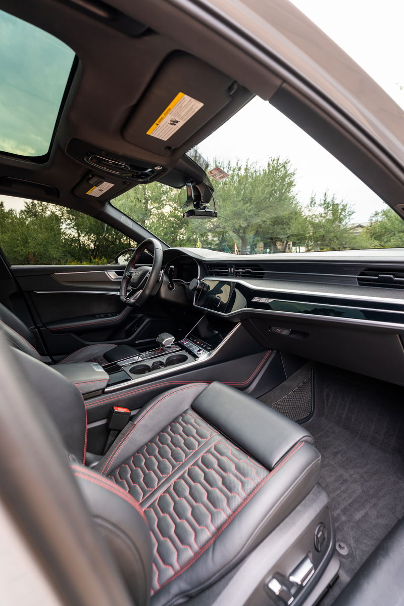 2022 Audi RS6 interior: Nardo Grey paint, panoramic sunroof, honeycomb stitched leather seats with red accents.