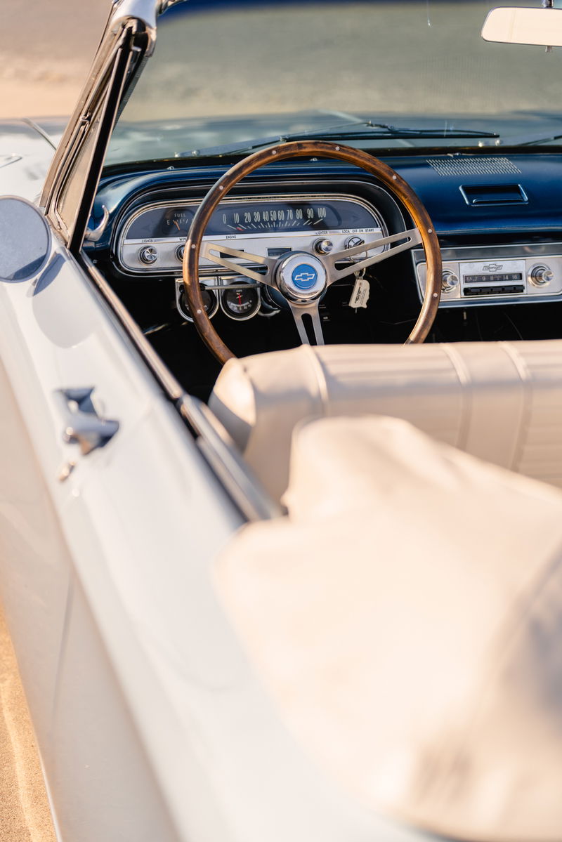1966 Chevrolet Corvair convertible interior with wood-rimmed steering wheel and blue metallic dash trim.