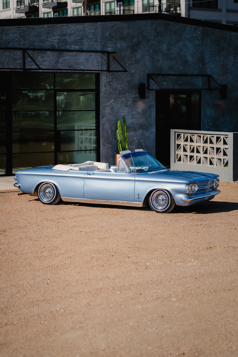 Light blue metallic 1966 Chevrolet Corvair convertible with chrome rims and trim.