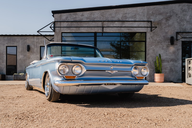 Light blue 1966 Chevrolet Corvair convertible with chrome rims and trim.