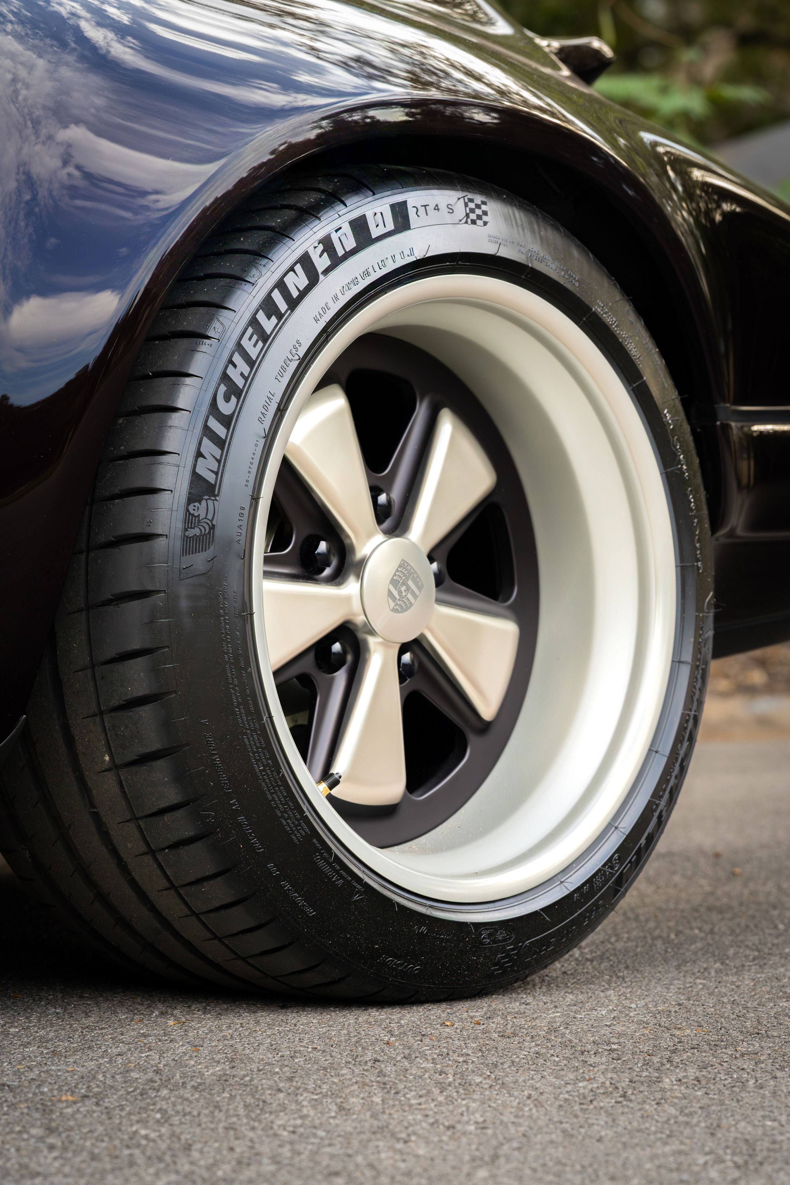 Close up of an Aubergine Metallic 1990 Singer Porsche 911 wheel with Michelin tires.