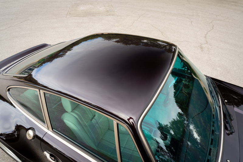Top view of a black 1990 Singer Porsche 911 showing glossy roof and turquoise tinted glass.