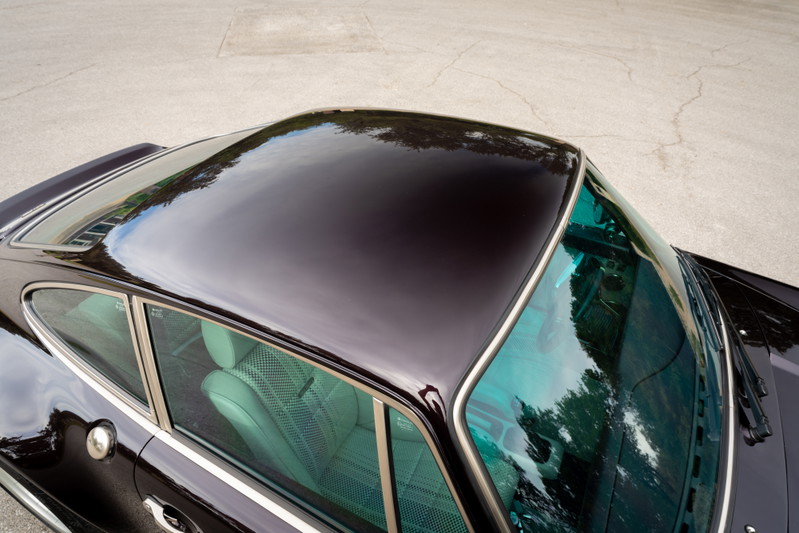 Top view of a black 1990 Singer Porsche 911 showing glossy roof and turquoise tinted glass.