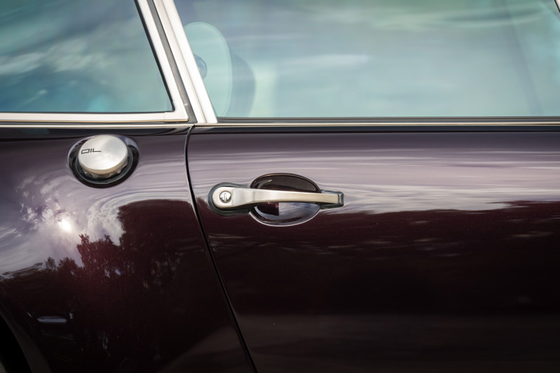 Aubergine metallic 1990 Singer 911 door with chrome trim, oil cap, and door handle.