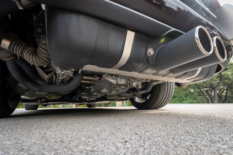 1990 Porsche 911 Singer aubergine metallic: dual chrome exhaust tips, underbody detail.