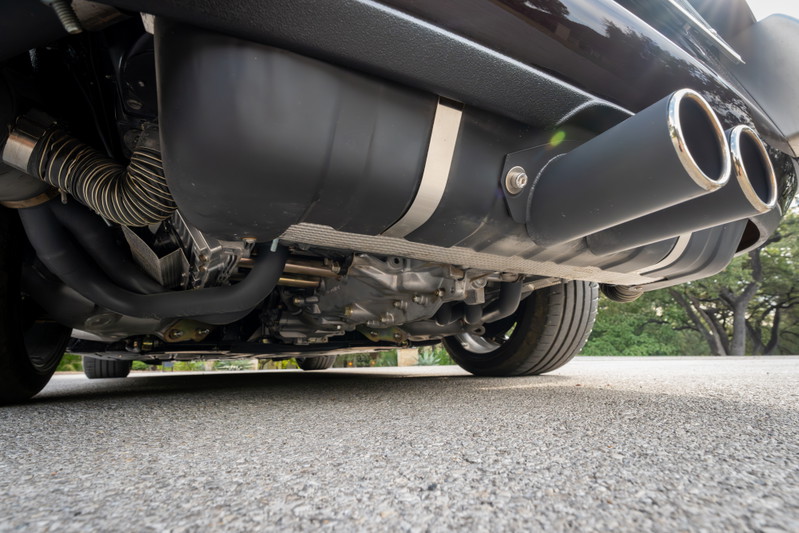 1990 Porsche 911 Singer aubergine metallic: dual chrome exhaust tips, underbody detail.