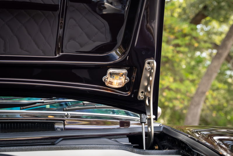 1990 Singer Porsche 911 Aubergine Metallic hood with illuminated emblem and chrome trim.