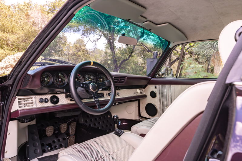Singer 911 interior, aubergine metallic accents, vintage dashboard, and checkered seats.