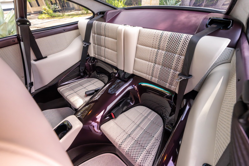 Aubergine metallic Singer 911 rear interior with plaid seat inserts and dark trim.