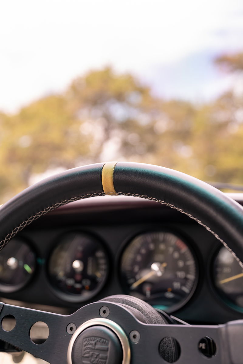 1990 Singer Porsche 911 interior: close-up on steering wheel with yellow 12 o'clock marker.