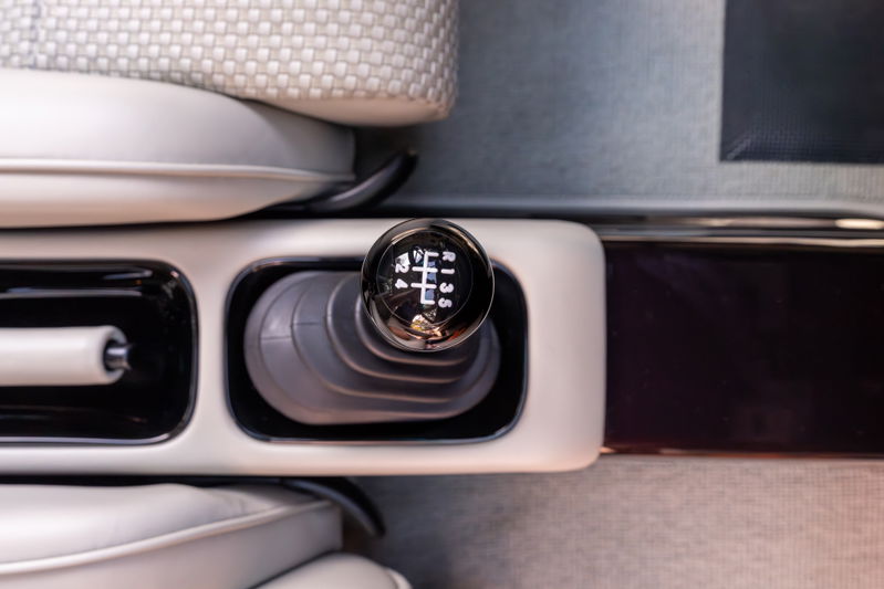 Close-up of a 1990 Singer 911's aubergine metallic manual gear shifter and console.