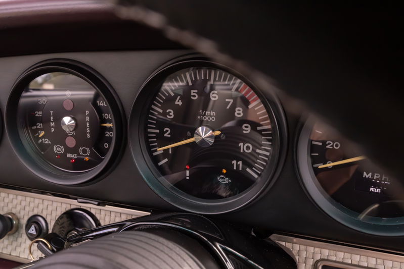 Close-up of a 1990 Singer Porsche 911 dashboard, showing tachometer, oil pressure, and speed gauges.
