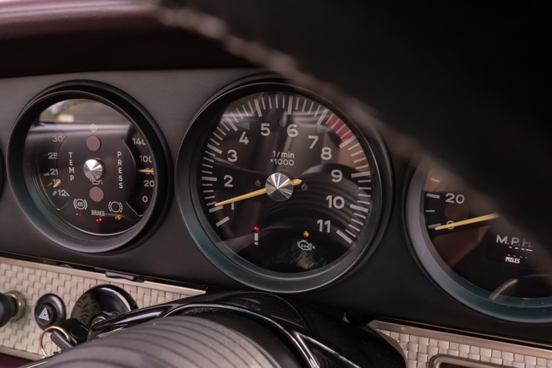 Close-up of a 1990 Singer Porsche 911 dashboard, showing tachometer, oil pressure, and speed gauges.