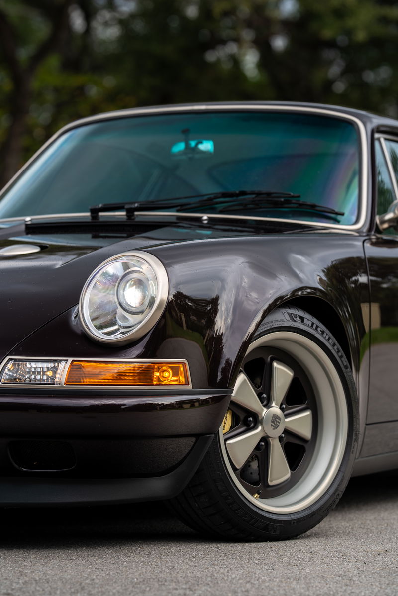 Aubergine Metallic 1990 Singer Porsche 911 front fender with classic Fuchs-style rims.
