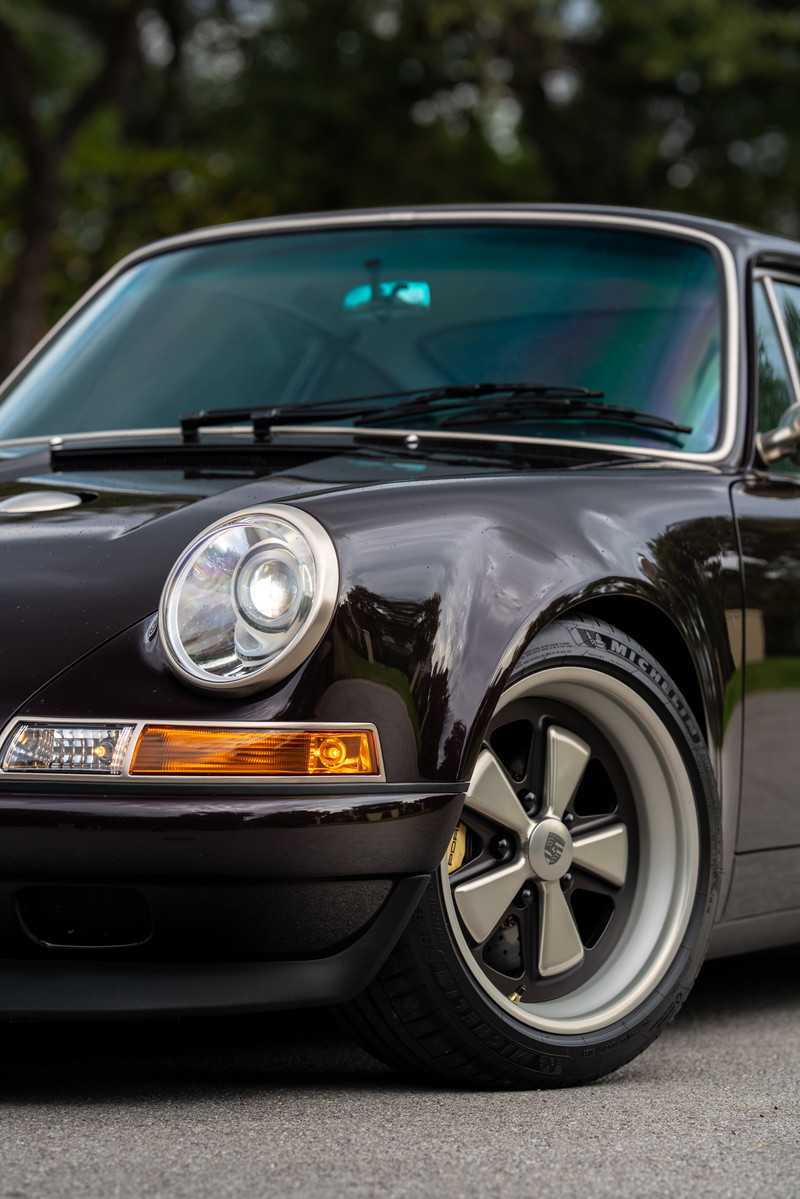 Aubergine Metallic 1990 Singer Porsche 911 front fender with classic Fuchs-style rims.