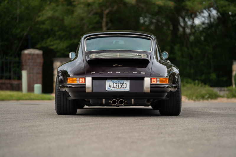 Aubergine metallic 1990 Singer Porsche 911 rear view with chrome trim and dual exhaust.