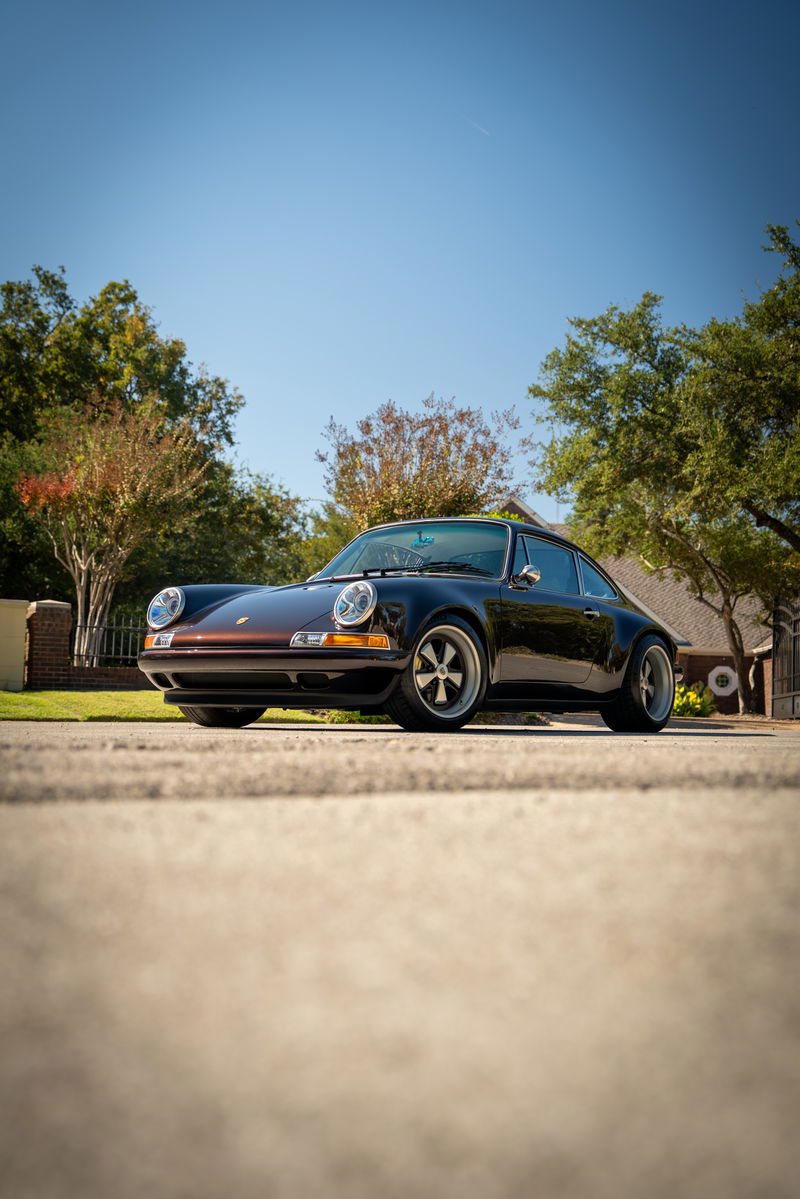 Aubergine metallic 1990 Singer 911 Porsche with silver alloy rims and chrome trim.