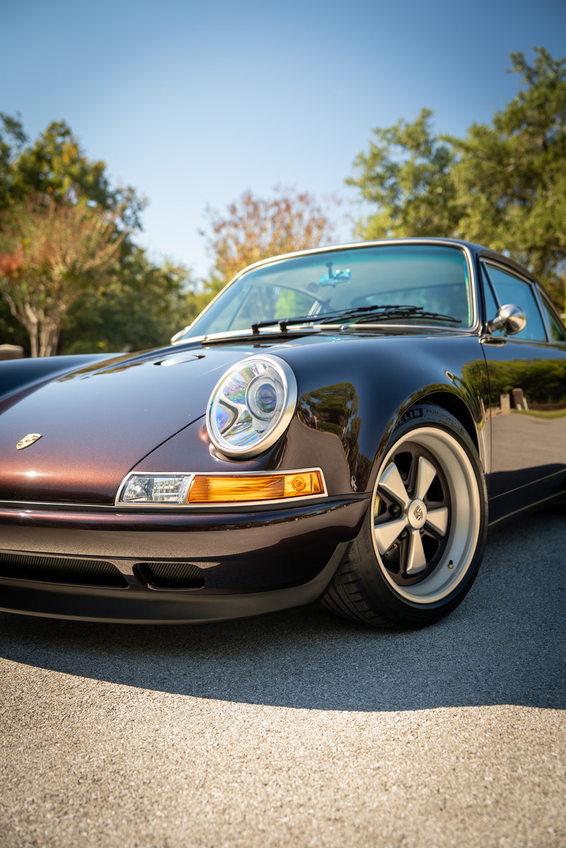 Aubergine Metallic 1990 Singer 911 front quarter, showing Fuchs wheels and chrome trim.