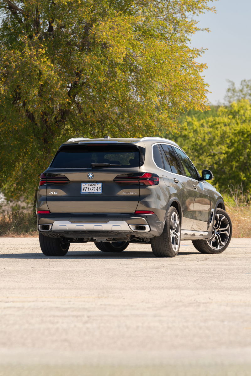 2026 BMW X5 in Manhattan Green with large alloy rims and silver skid plate.