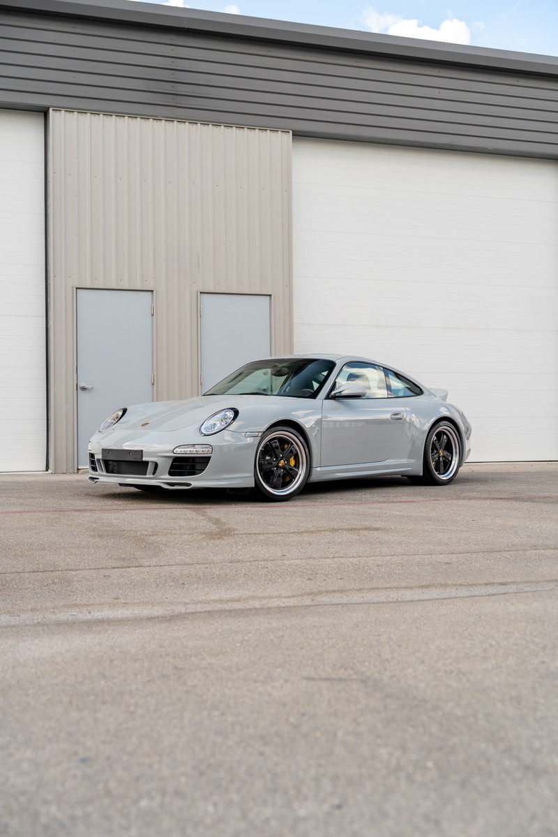 2010 Porsche 911 Sport Classic in light grey with black rims and yellow brake calipers.