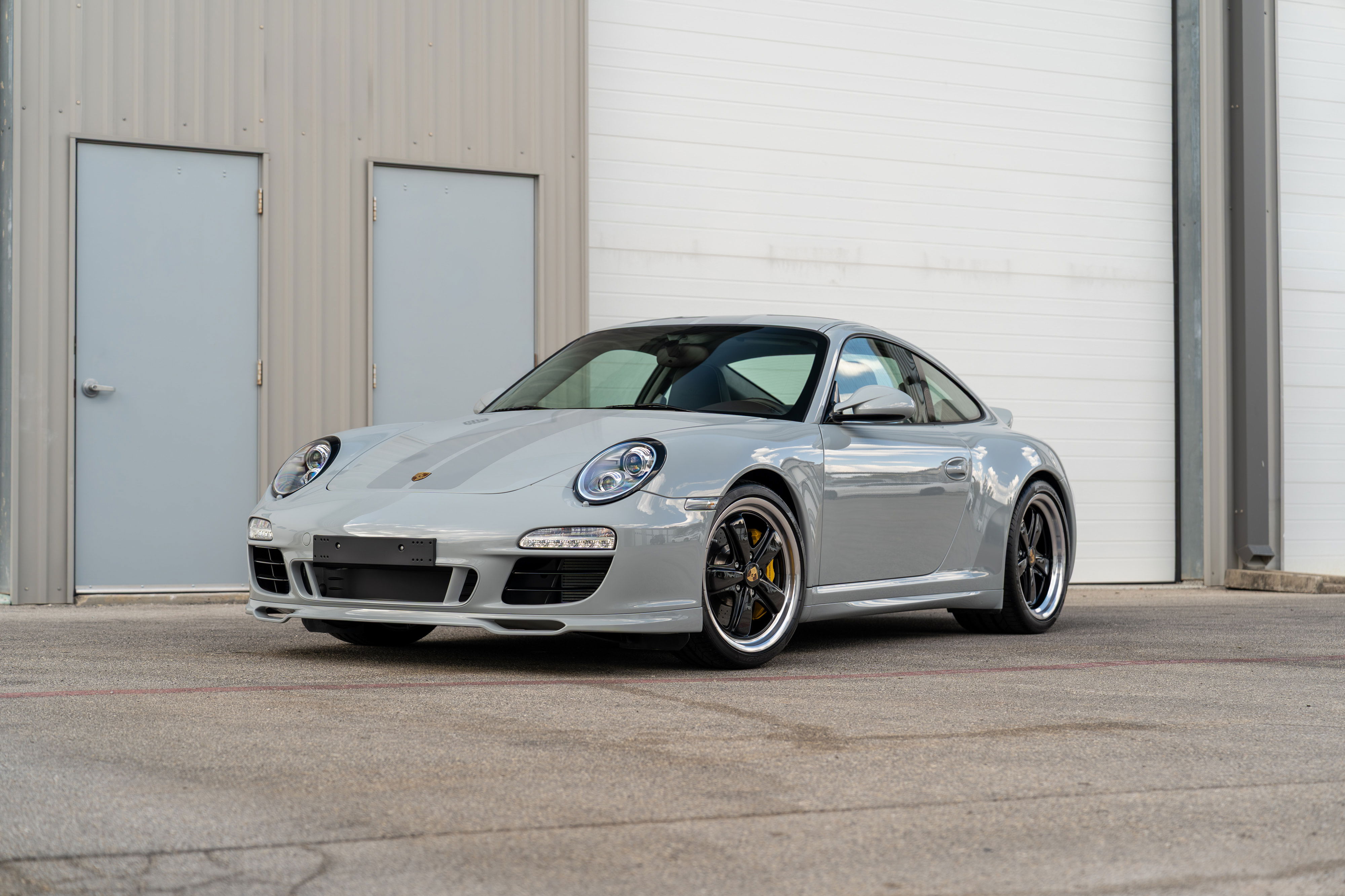 2010 Porsche 911 Sport Classic in Sport Grey, featuring black rims and yellow brake calipers.