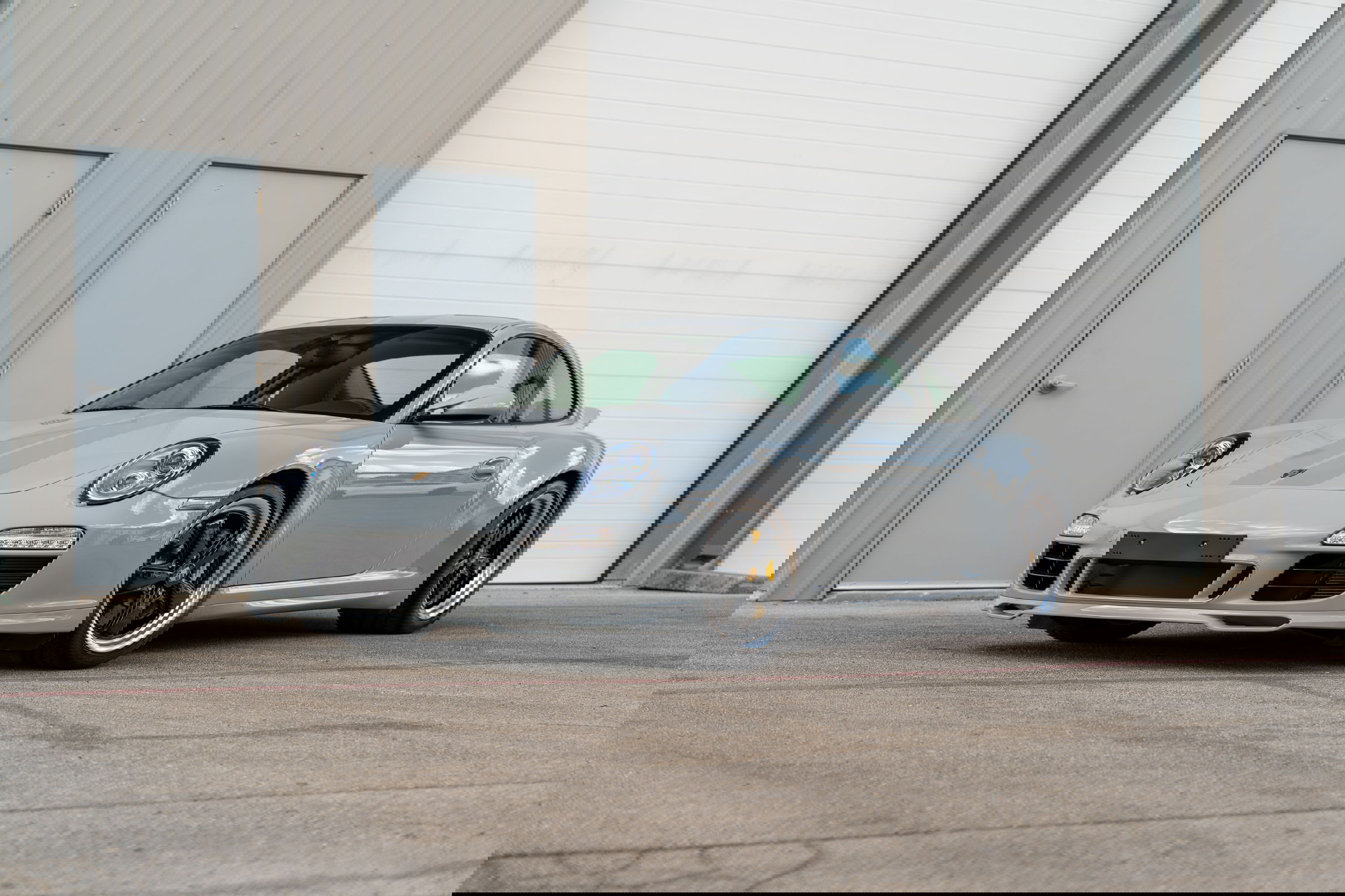2010 Porsche 911 Sport Classic in Sport Grey, featuring black rims and yellow brake calipers.