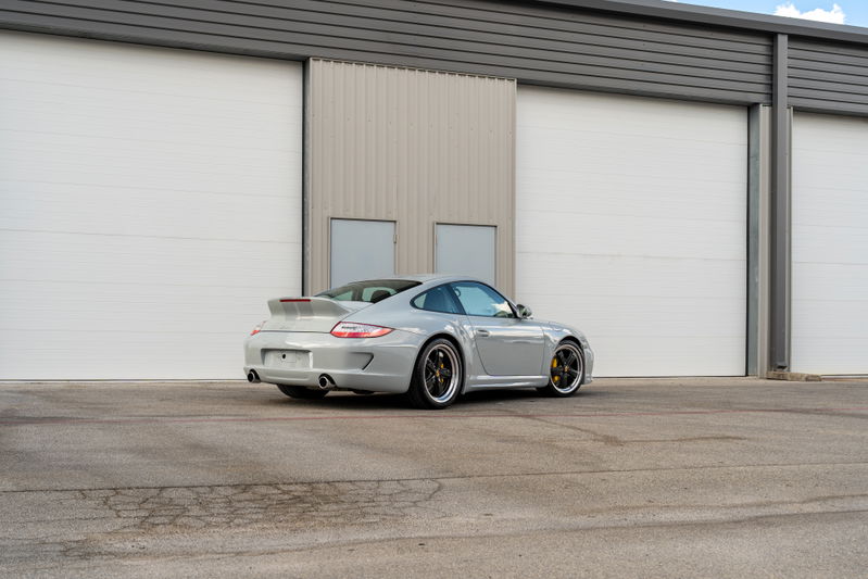 2010 Porsche 911 Sport Classic in grey, featuring multi-spoke rims and a large rear spoiler.