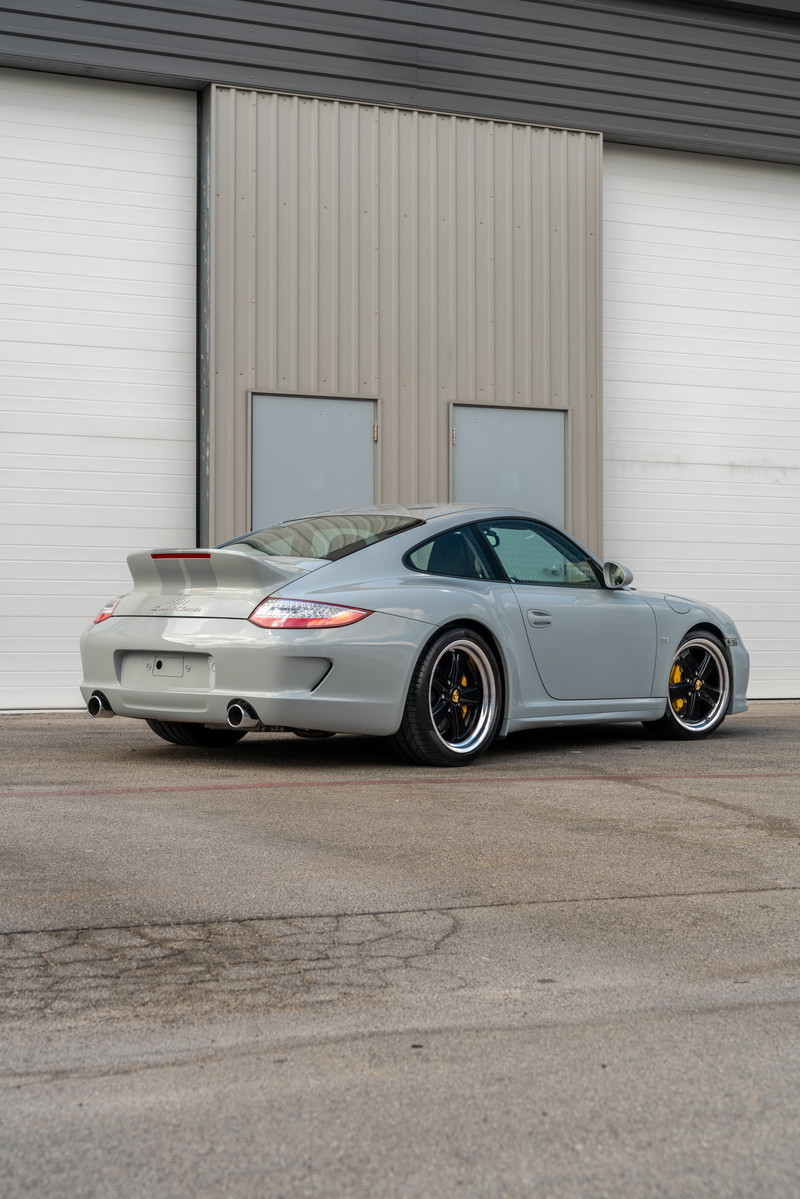 2010 Porsche 911 Sport Classic in Sport Grey, with silver racing stripes and black multi-spoke rims.