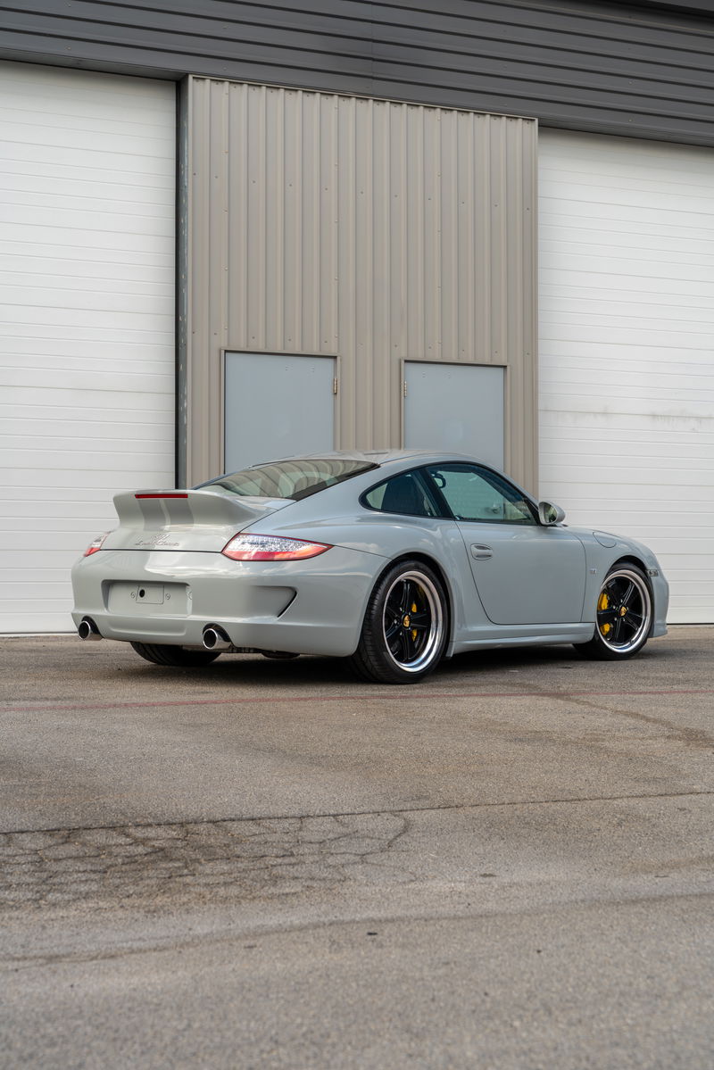 2010 Porsche 911 Sport Classic in Sport Grey, with silver racing stripes and black multi-spoke rims.