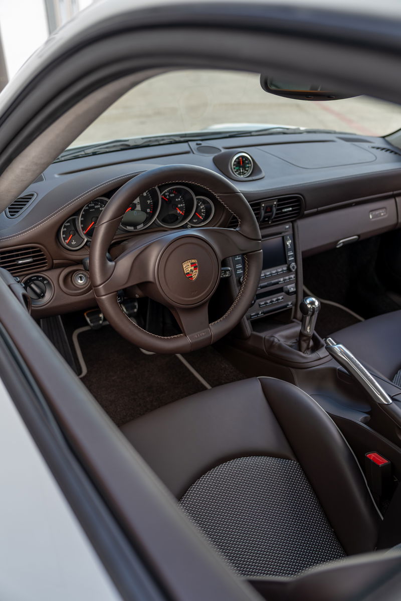 2010 Porsche 911 Sport Classic interior with brown leather trim and Porsche crest steering wheel.