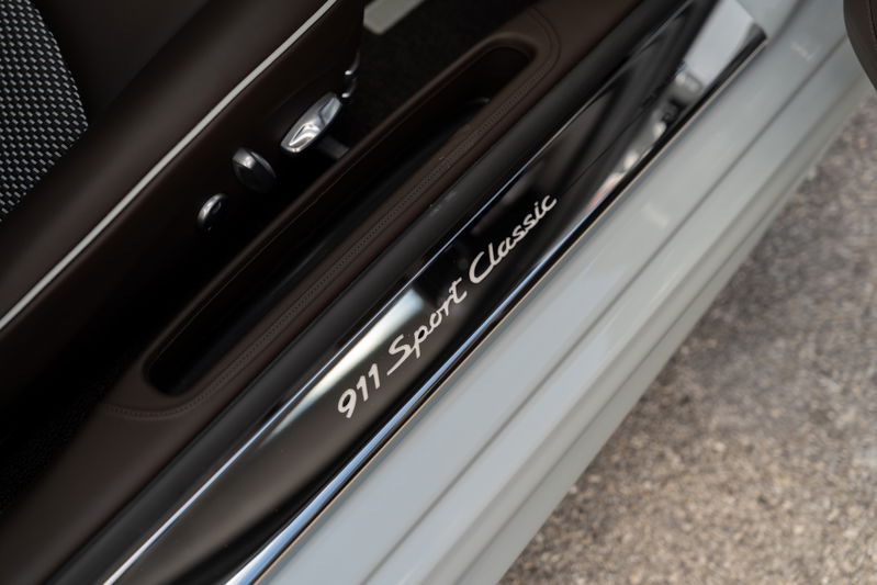 Close-up of the "911 Sport Classic" script on the illuminated door sill of a 2025 Porsche 911 Sport Classic.