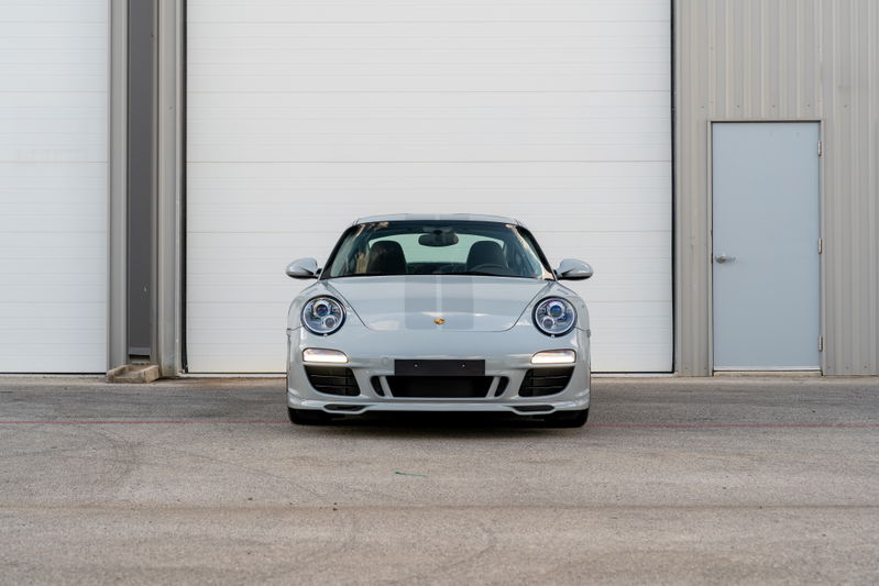 Front view of a grey 2010 Porsche 911 Sport Classic with racing stripes and silver rims.
