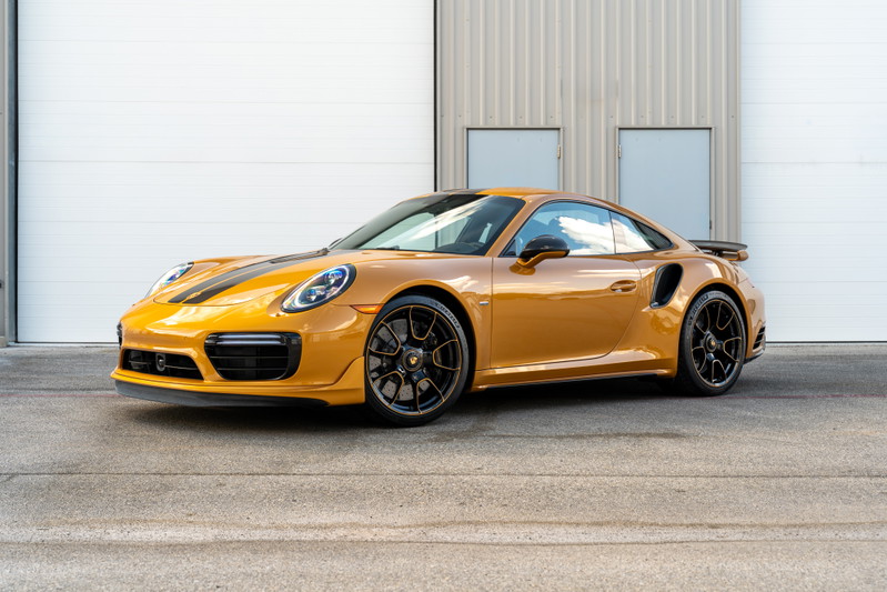 2018 Porsche 911 Turbo S Exclusive Series in gold with black racing stripes, black rims, and spoiler.