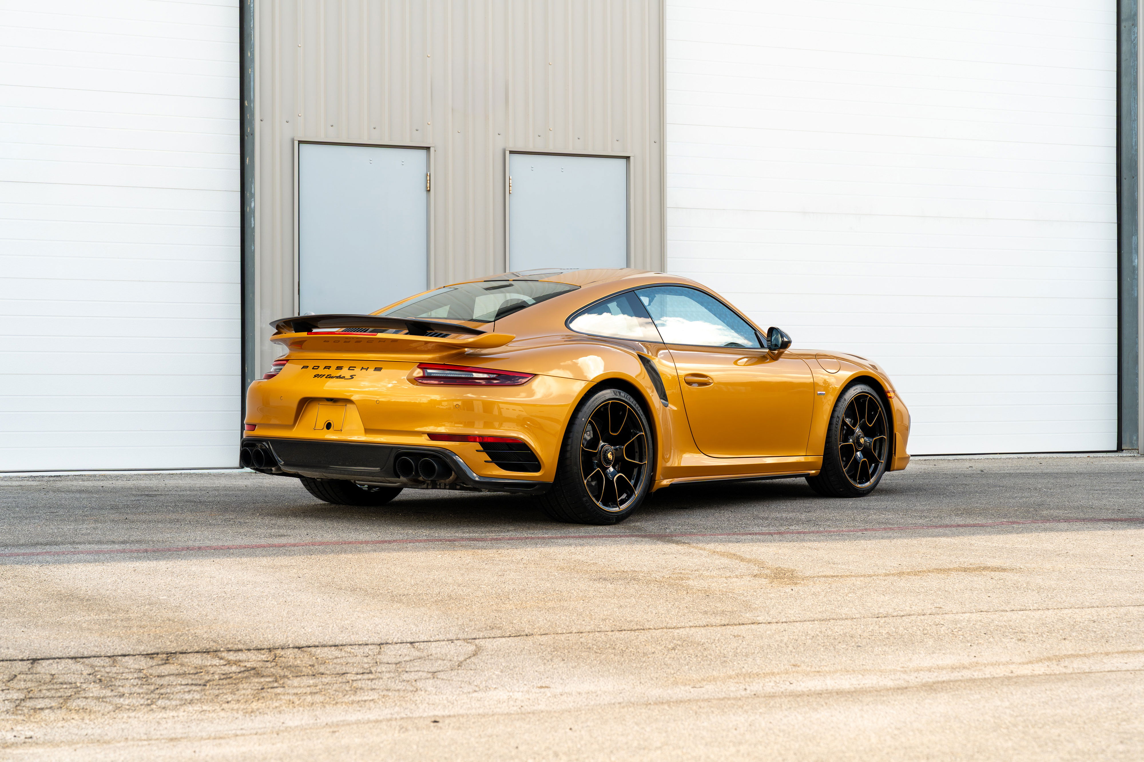 2018 Porsche 911 Turbo S Exclusive Series in gold with black rims and spoiler.