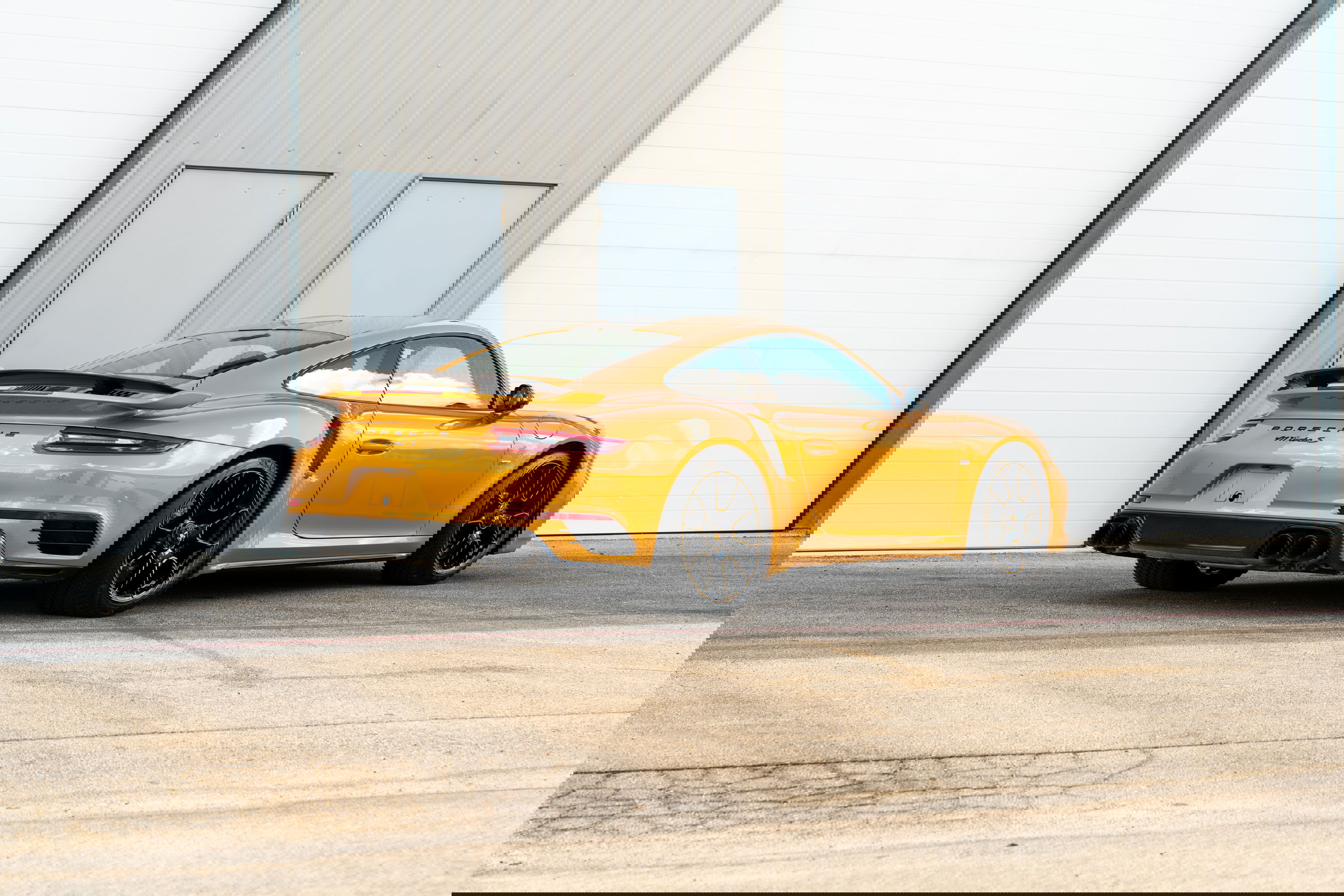 2018 Porsche 911 Turbo S Exclusive Series in gold with black rims and spoiler.