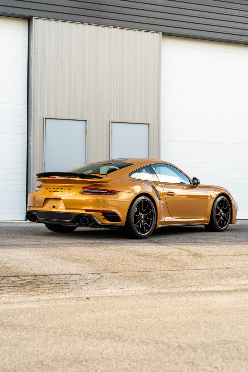 Golden 2018 Porsche 911 Turbo S Exclusive Series with black wheels and spoiler.