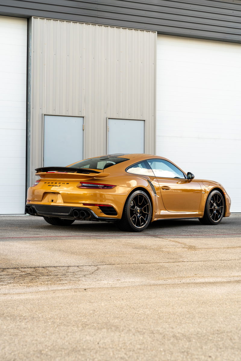 Golden 2018 Porsche 911 Turbo S Exclusive Series with black wheels and spoiler.