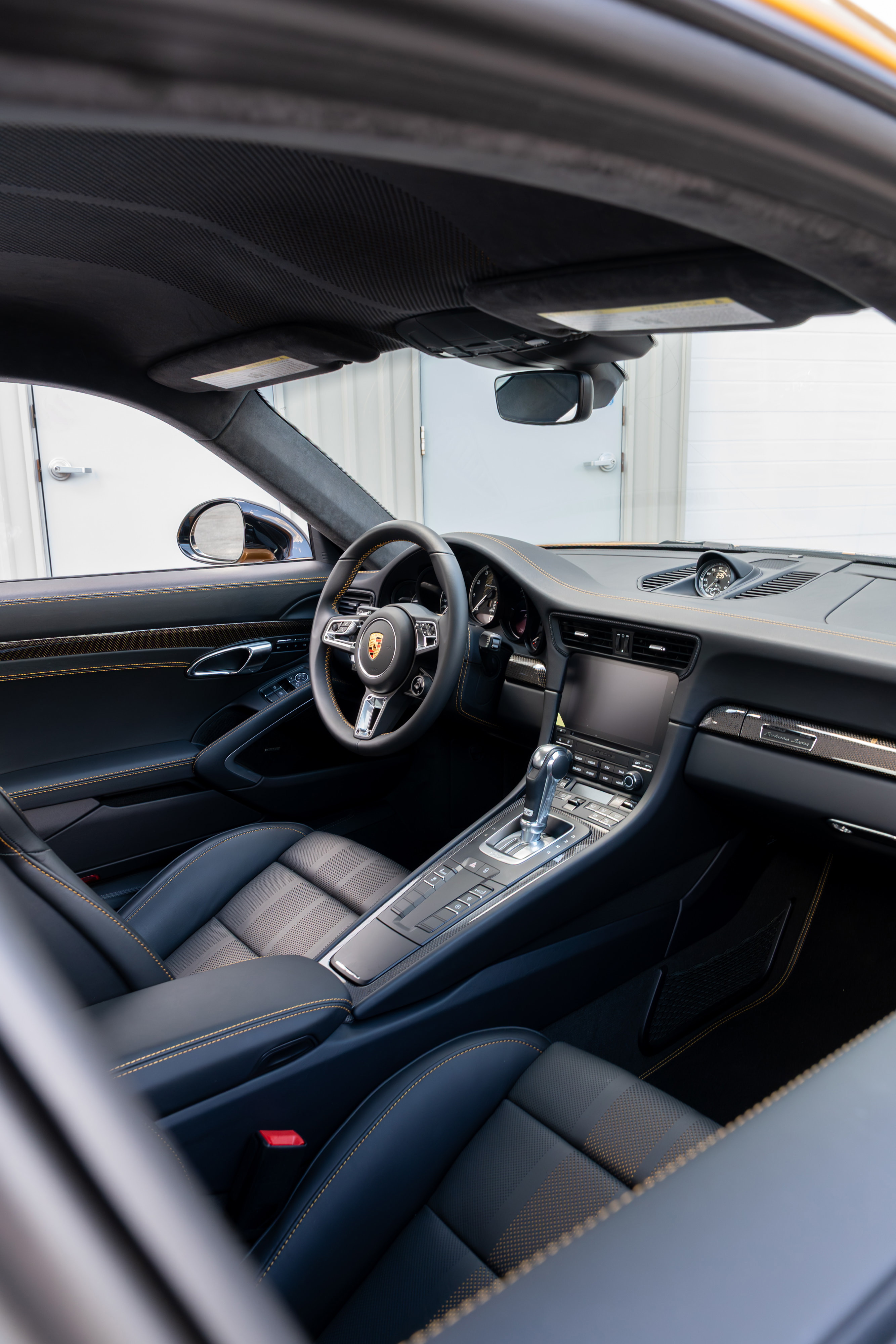 2018 Porsche 911 Turbo S Exclusive Series interior with black leather trim and yellow stitching.