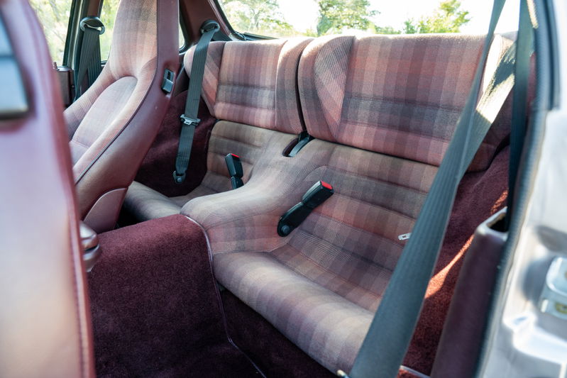 1987 Porsche 944 Turbo S interior with plaid fabric seats and maroon carpeting.