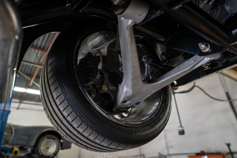 Close-up view of a classic 1965 Chevrolet Corvette's suspension and tire.