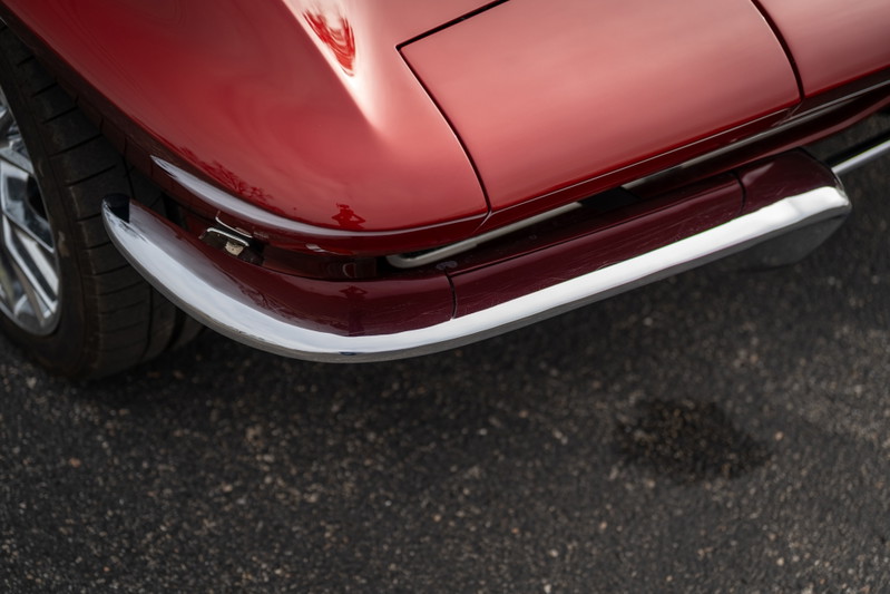 1965 Corvette Stingray, cherry red. Chrome bumper and trim highlight the iconic front end.