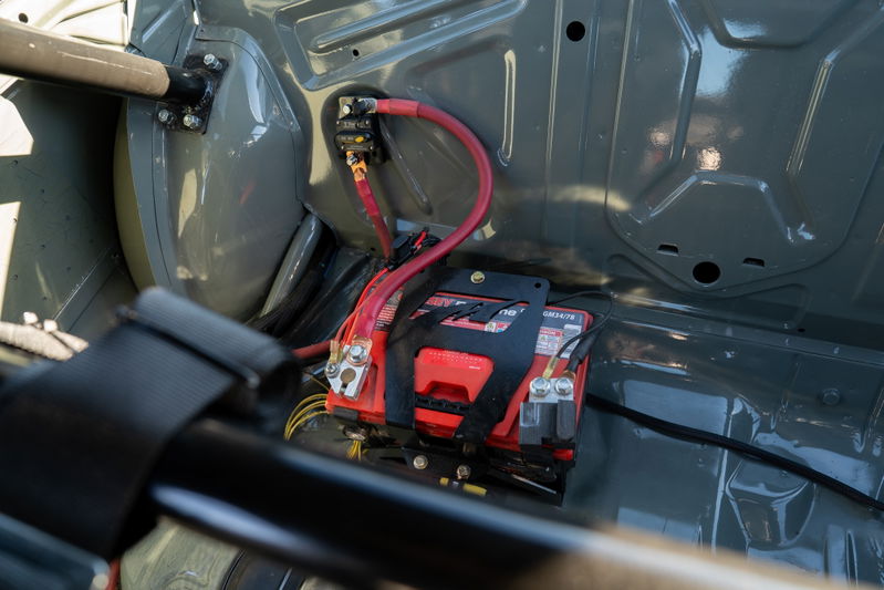 1989 BMW 325is LS1 swap battery relocation with red terminals and roll cage.