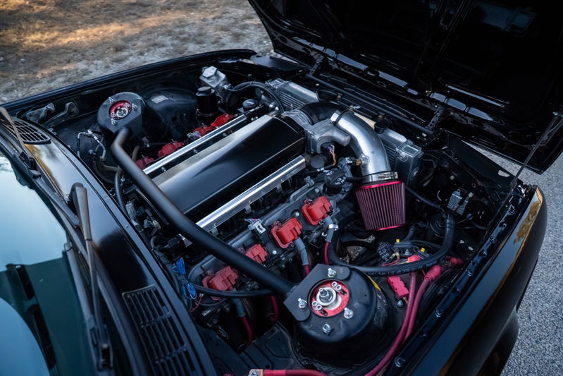 Black 1989 BMW 325is with LS1 engine swap, custom intake and red coil packs.